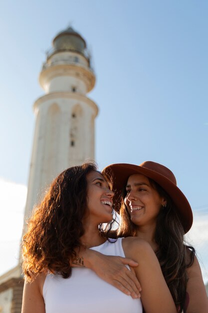 Medium shot women posing with lighthouse