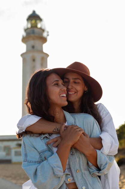 Medium shot women posing with lighthouse