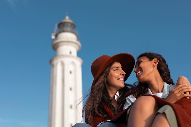 Medium shot women posing with lighthouse