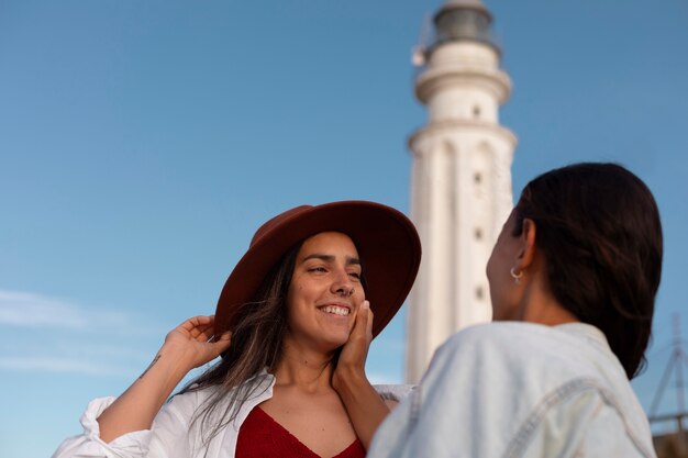 Medium shot women posing with lighthouse