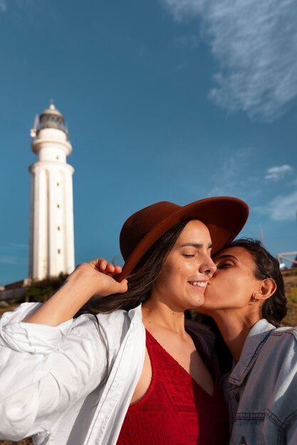 Medium shot women posing with lighthouse