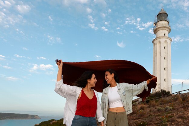 Medium shot women posing with lighthouse