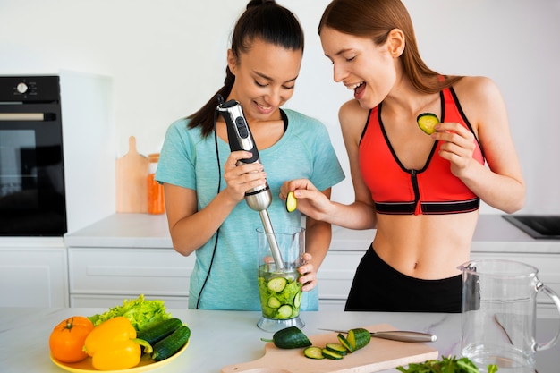 Free photo medium shot women preparing smoothie