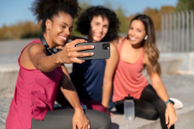 Medium shot women taking selfie