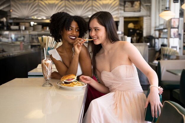 Medium shot women with burgers and fries