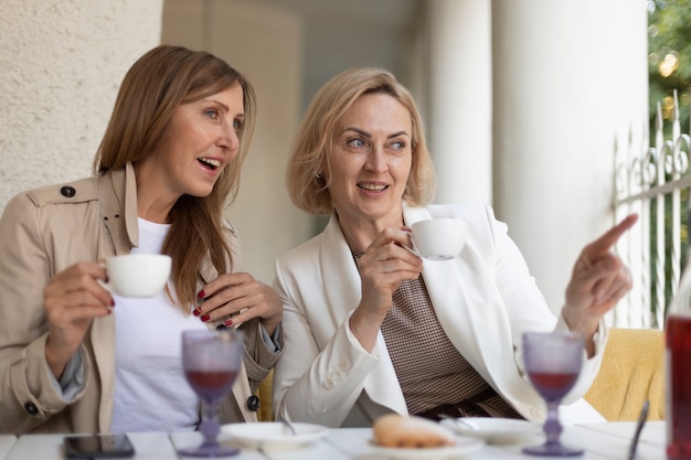 Medium shot women with coffee cups