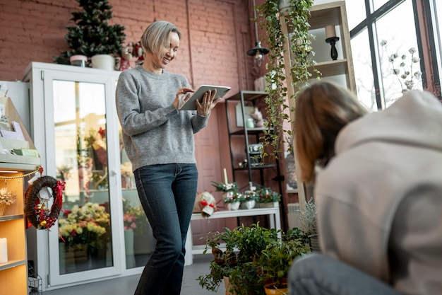 Free photo medium shot women working at flower shop