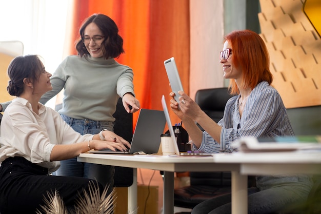 Free Photo medium shot women working together at officec