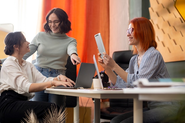 Medium shot women working together at officec