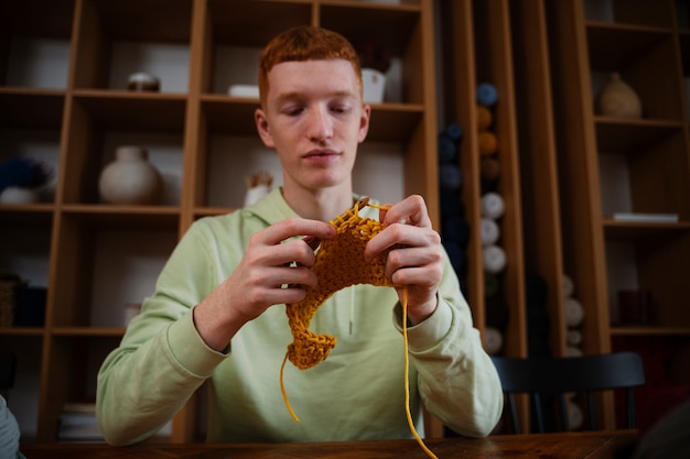 Free photo medium shot young man knitting