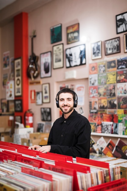 Medium shot of young man looking at camera in vinyl store