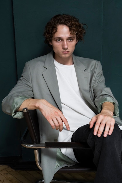 Free photo medium shot young man posing on chair