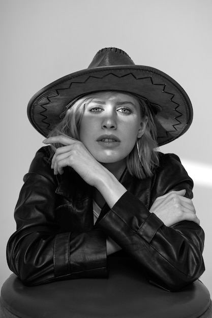 Free photo medium shot young model posing with hat black and white