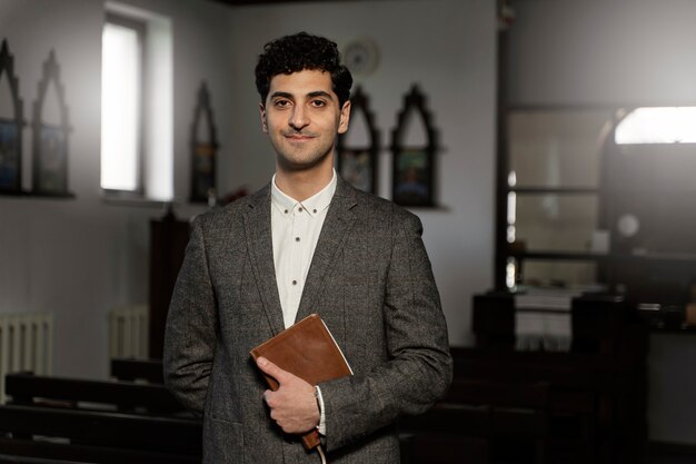 Medium shot young pastor holding bible