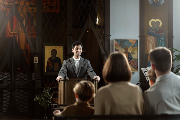 Free photo medium shot young pastor preaching at church