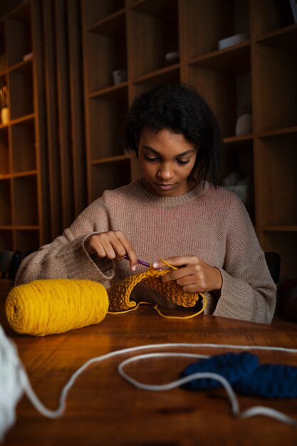 Medium shot young woman crocheting