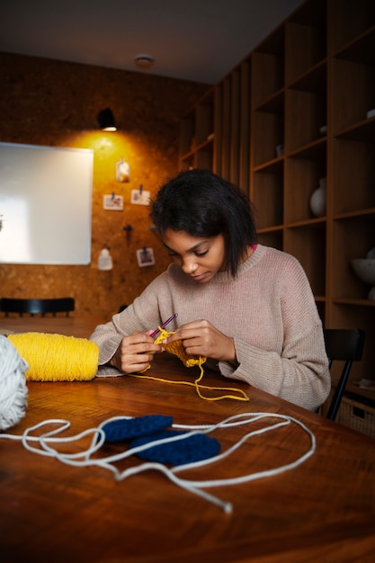 Medium shot young woman crocheting