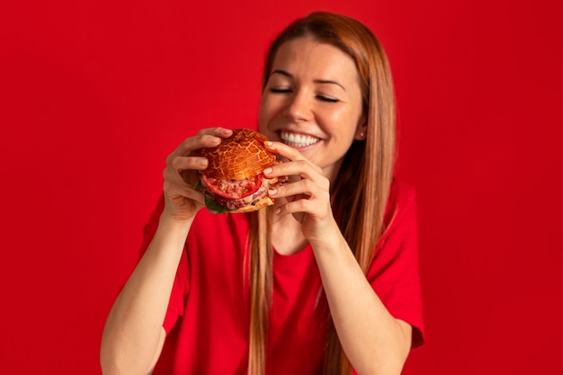 Free photo medium shot young woman eating burger