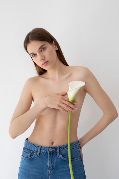 Free photo medium shot young woman posing with flower