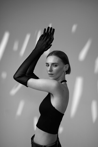 Medium shot young woman posing with gloves black and white