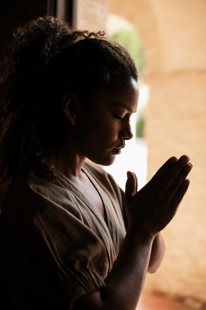 Medium shot young woman praying