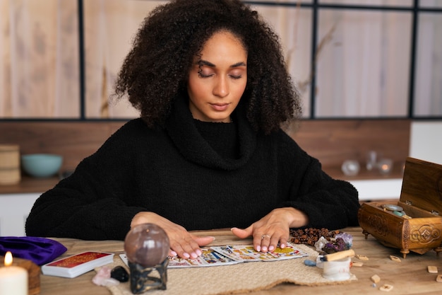 Free photo medium shot young woman reading tarot