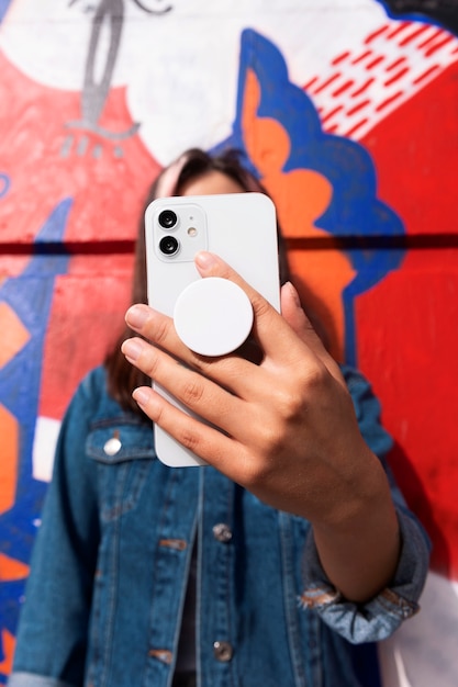 Free photo medium shot young woman using popsocket