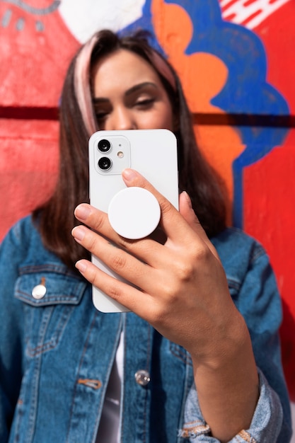 Free photo medium shot young woman using popsocket