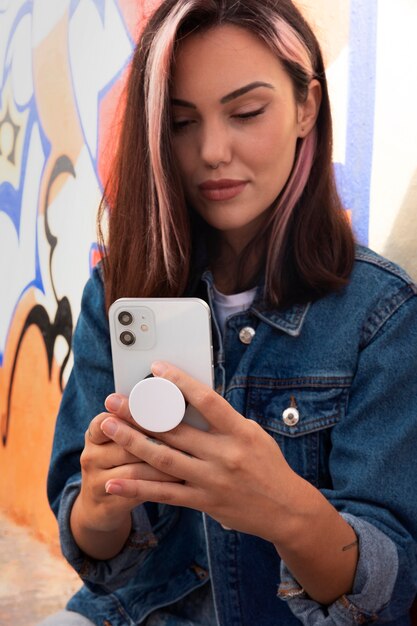 Medium shot young woman using popsocket