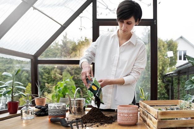 Medium shot young woman with potting soil bag