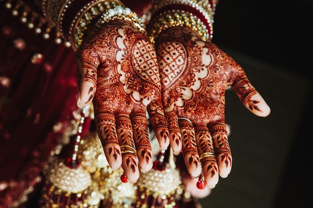 Mehndi wedding ornament on the hands drawn by henna