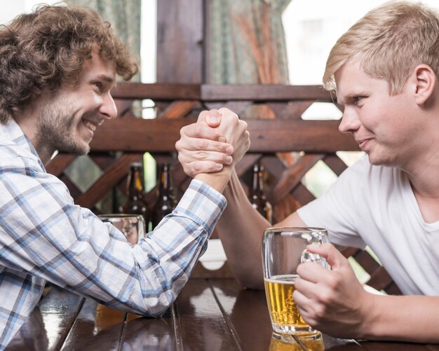 Men arm wrestling in bar