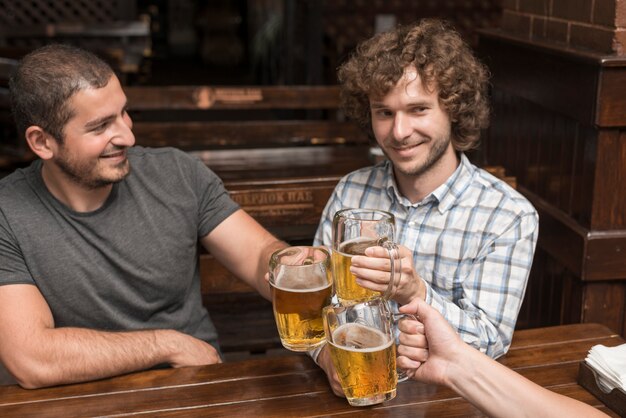 Men celebrating with friend in bar