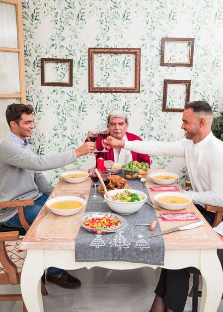 Men clanging glasses at festive table