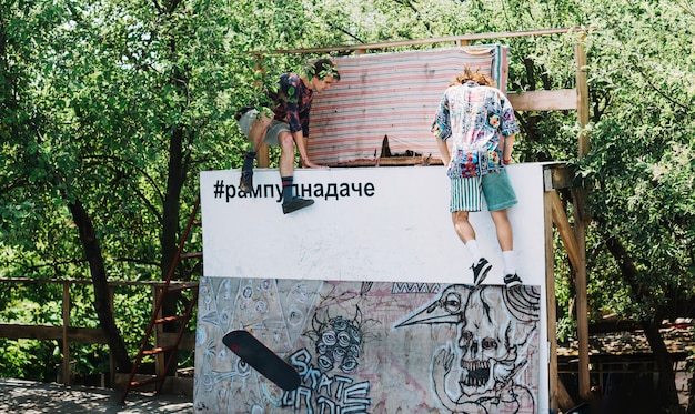 Free photo men climbing on ramp in skatepark