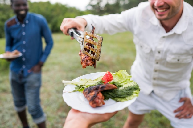 Free photo men cooking barbecue outdoors