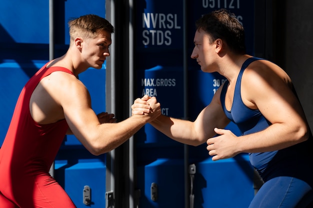 Free Photo men demonstrating wrestling combat moves