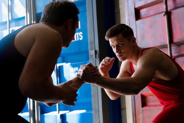 Men demonstrating wrestling combat moves