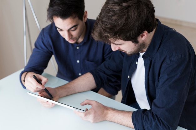 Men discussing data on tablet