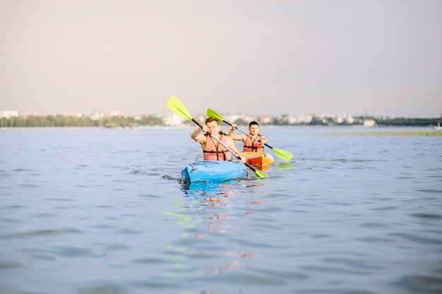 Men kayaking down on lake