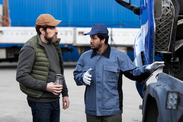 Free photo men looking inside truck side view