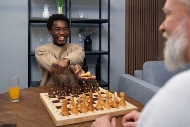 Men playing chess indoors side view