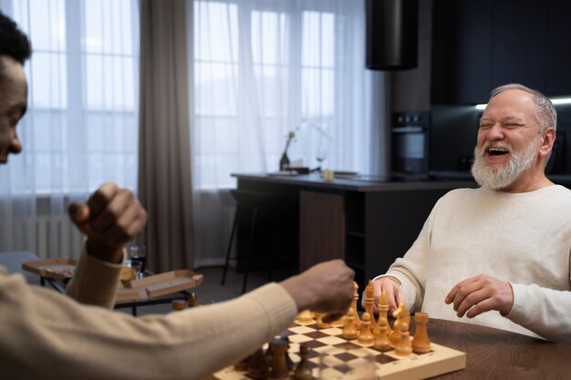 Men playing chess indoors side view