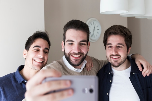 Men posing for selfie in office