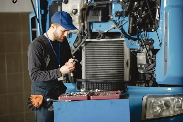 Free Photo men repair a truck. man teaches repair a car. two men in uniform