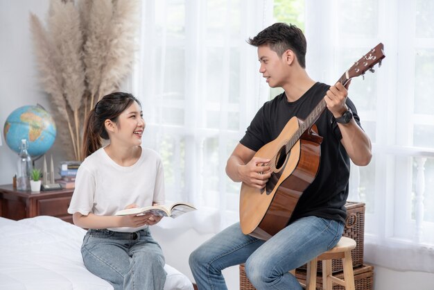 Men sitting guitar and women holding books and singing.