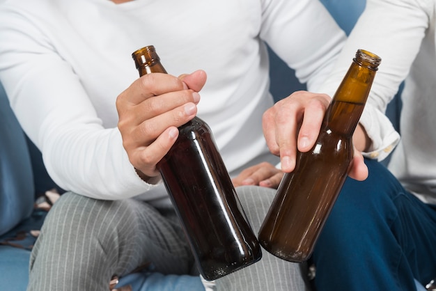 Free photo men sitting with beer on couch