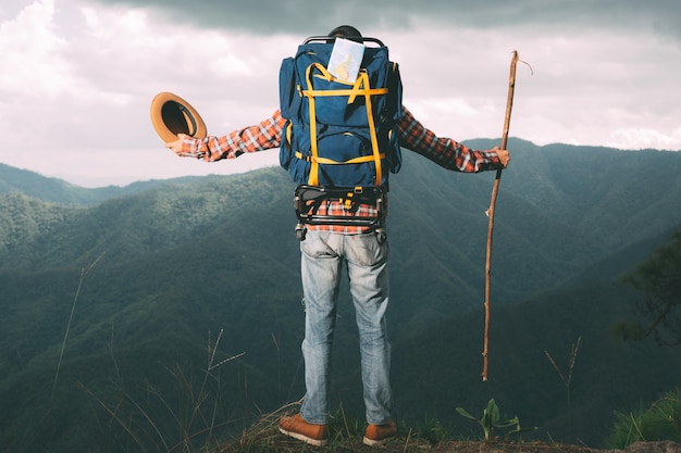 Men stand to watch mountains in tropical forests with backpacks in the forest. Adventure, traveling, climbing.