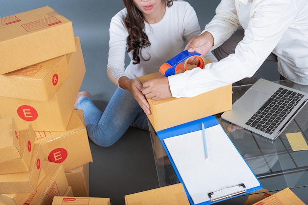 Men and women are helping to pack the boxes.