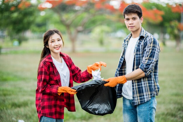 Men and women help each other to collect garbage.